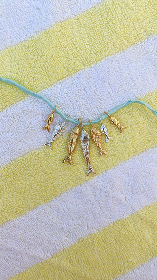 Gold fish figurines on a striped towel with green thread